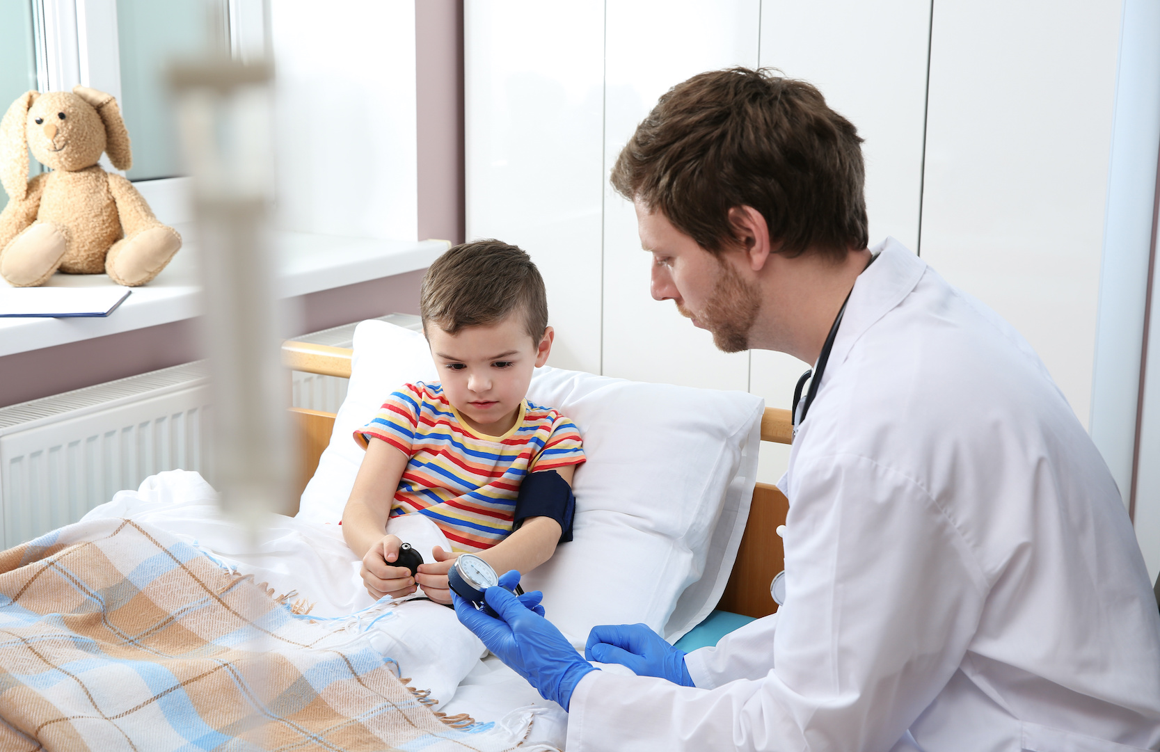 Doctor checking child’s blood pressure in hospital