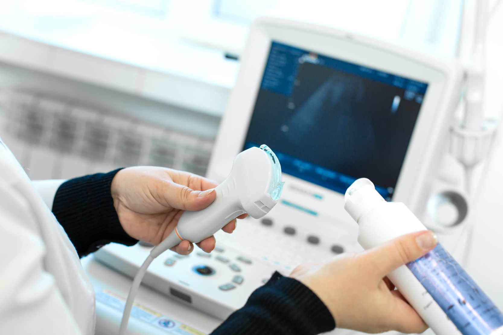Doctor prepare an ultrasound machine for the diagnosis of a patient. Doctor puts media gel on an ultrasound transducer