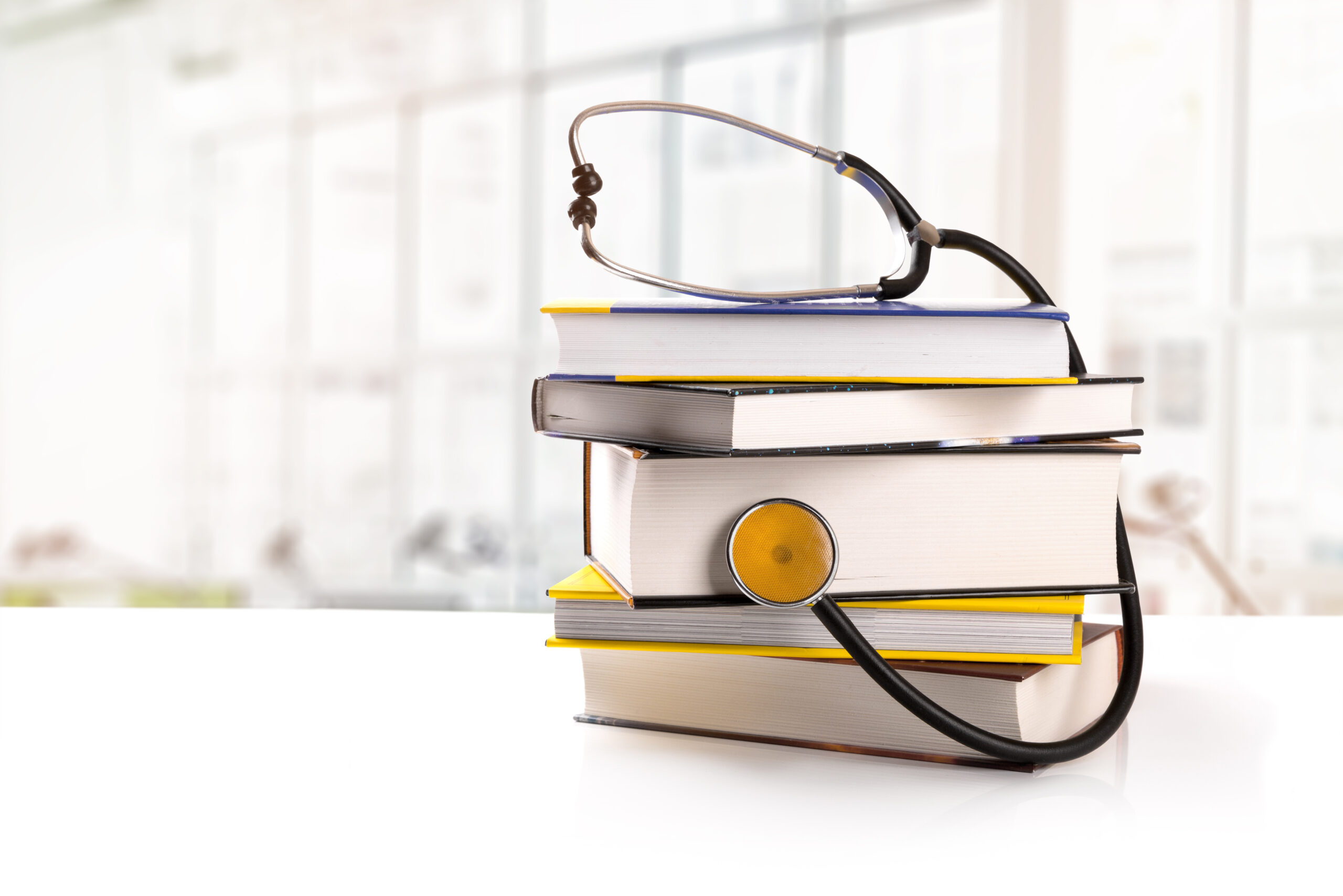 medical education – stack of books with stethoscope on the table