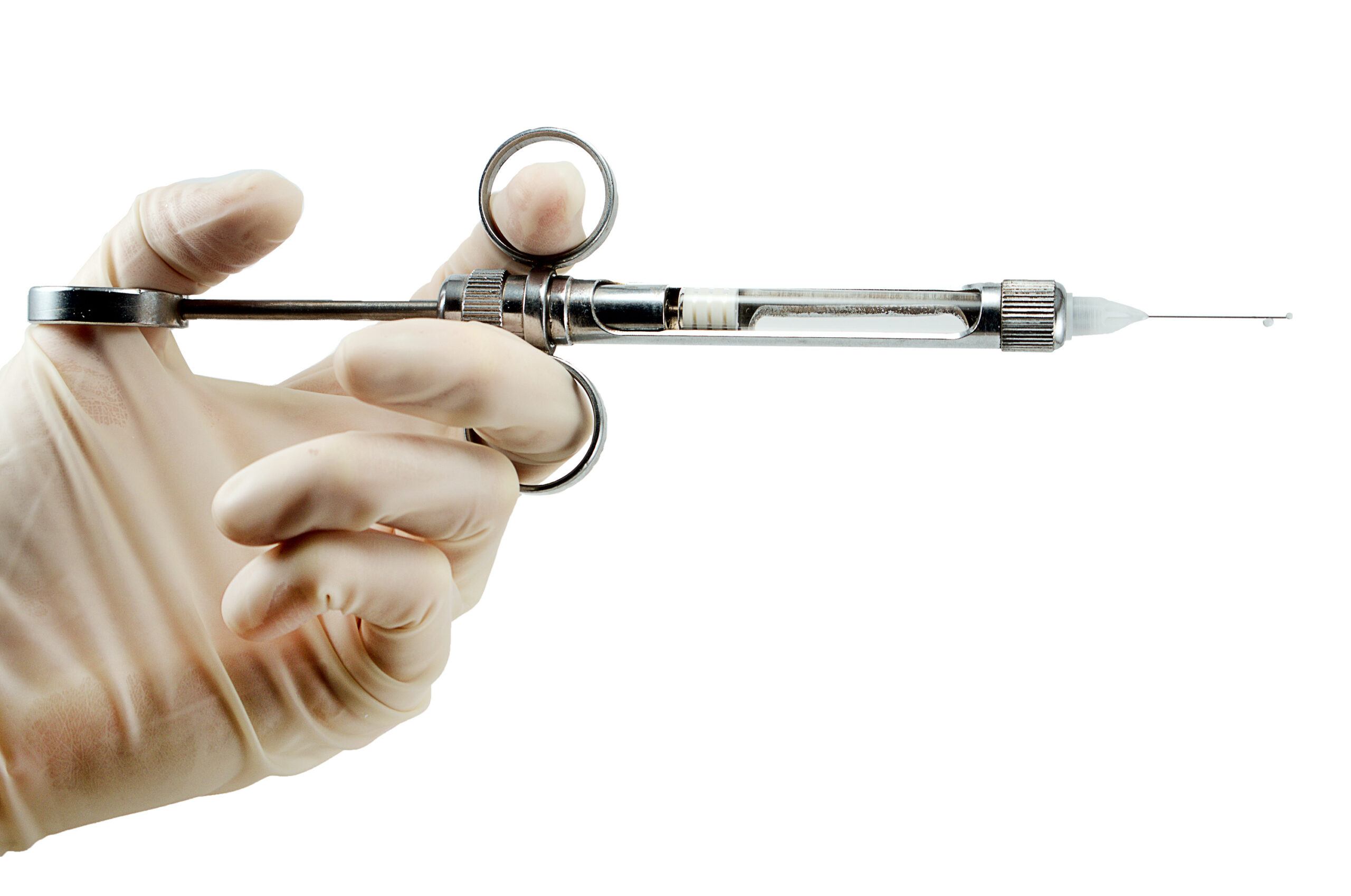 dentist’s hand with carpool syringe for local anesthesia on white background isolated